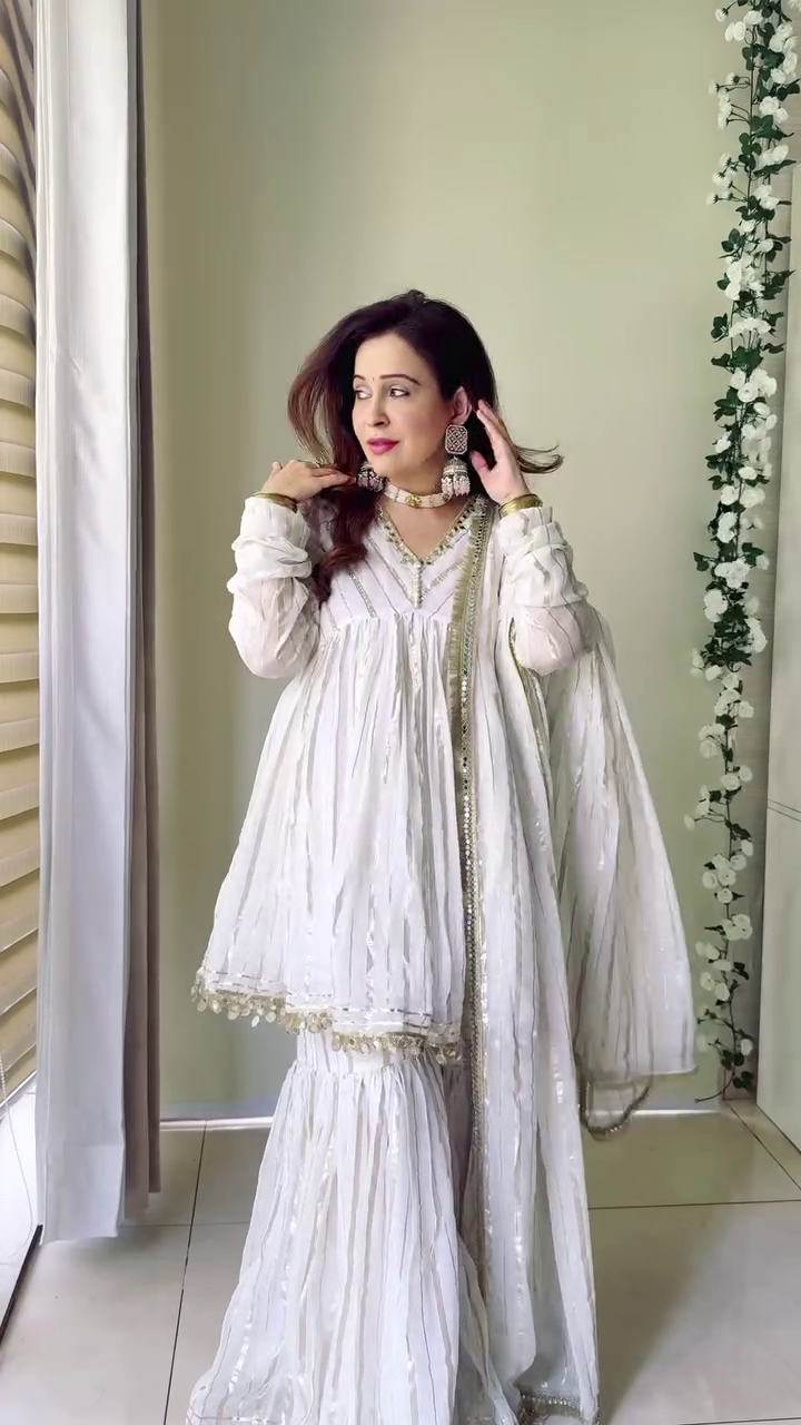 The outfit looks stunning! The white color with intricate detailing, paired with beautiful jewelry, gives a traditional and elegant vibe