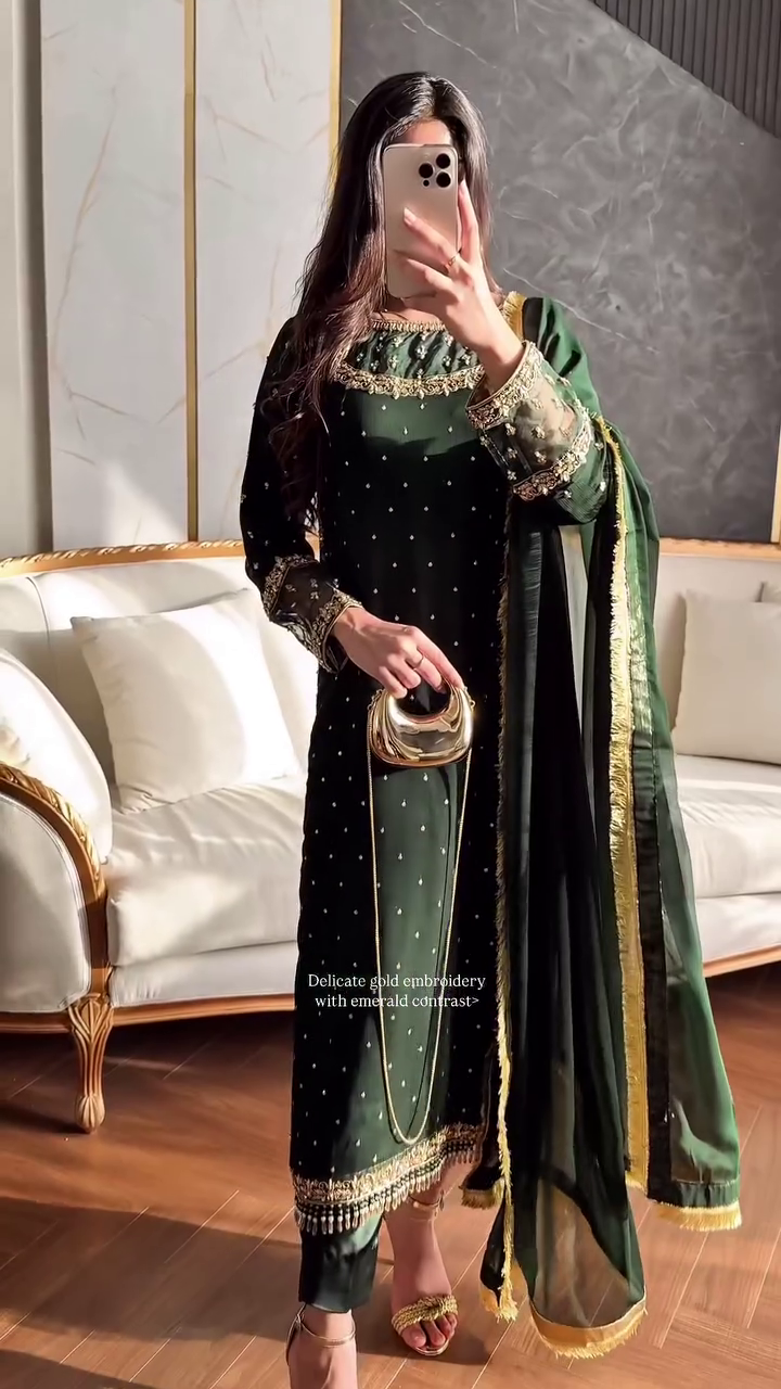 A stunning emerald green ethnic ensemble featuring delicate gold embroidery with an emerald contrast, paired with a matching dupatta and elegant gold accessories, perfect for a festive or formal occasion.