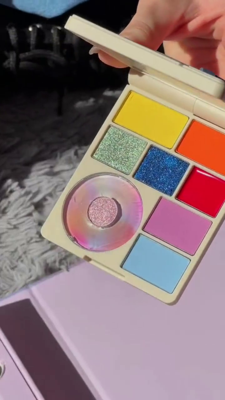 A versatile eyeshadow collection featuring vibrant, bold shades like yellow, orange, and blue with sparkling glitters