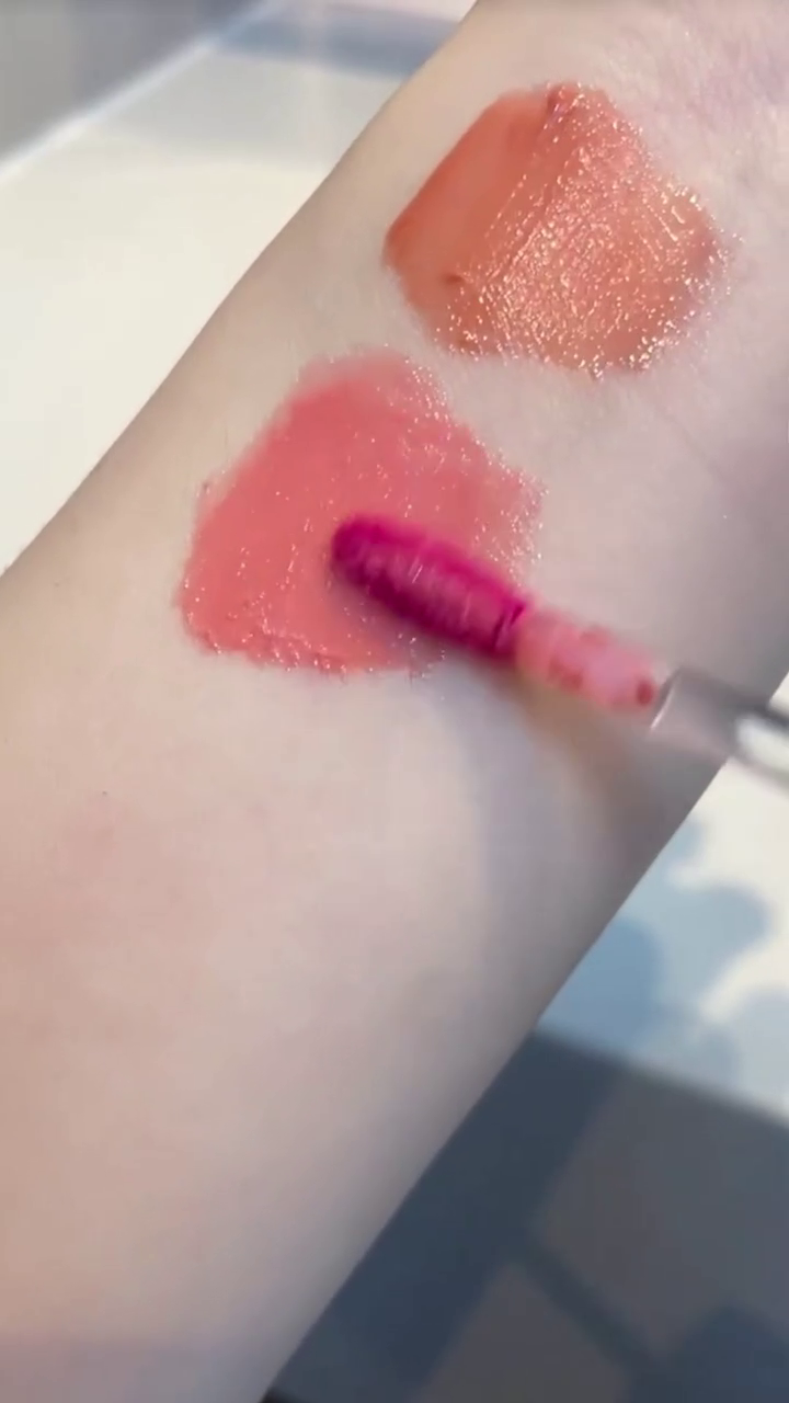 Two beautifully designed lipstick tubes in soft pastel colors, featuring intricate detailing on the cap, perfect for adding a touch of elegance and charm to your makeup collection.