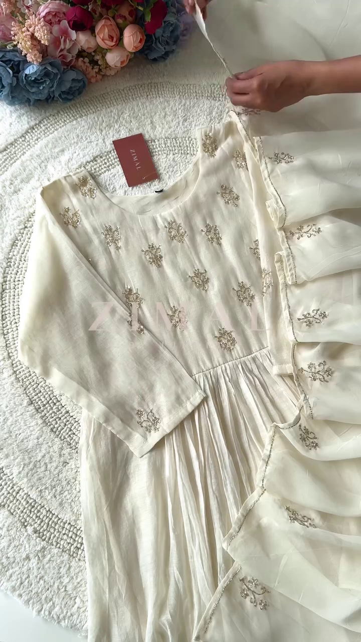 Elegant Cream-Colored Anarkali Dress with Delicate Embroidery and Pleated Detailing, Paired with a Soft Sheer Dupatta for a Graceful Look