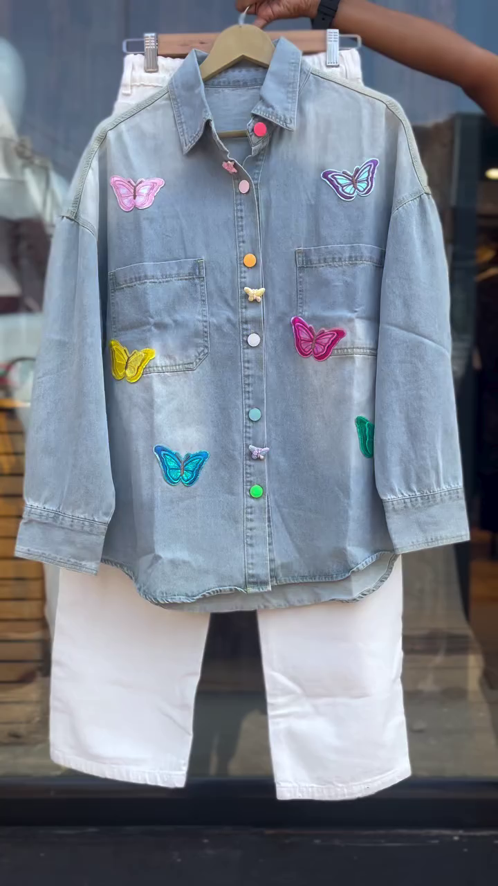 Trendy Two-Piece Set Featuring a Light Wash Denim Shirt Embellished with Colorful Butterfly Embroidery and Contrasting Multicolor Buttons, Paired with Classic High-Waist Straight-Cut White Jeans – Perfect for a Vibrant and Playful Casual Look