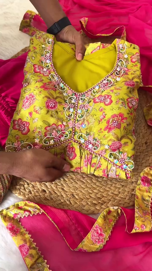 Vibrant Yellow Floral Printed Ethnic Suit Set with Intricate Neck Embroidery, Contrasting Hot Pink Dupatta with Border Detailing, and Coordinated Solid Pants – Ideal for Festive Celebrations and Traditional Gatherings